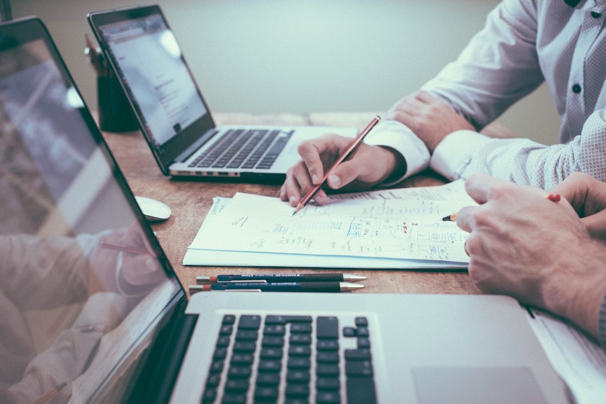 Escritorio con informes financieros, calculadora y computadora portátil